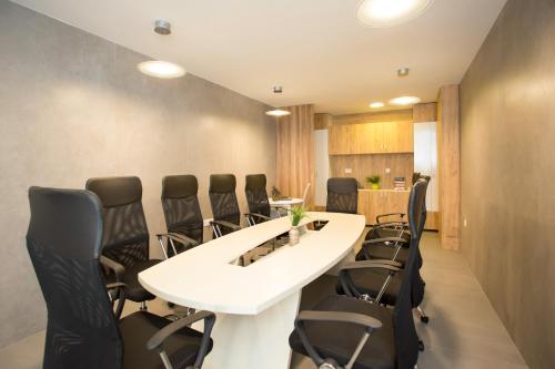 una sala de conferencias con una mesa blanca y sillas negras en Tilia, en Cetinje