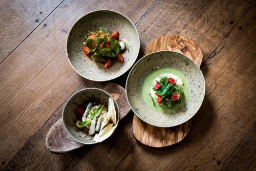 a group of three bowls of food on a wooden table at Fitz Roy Urban Hotel, Bar and Garden in Maastricht