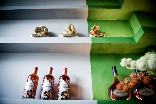 a shelf with three bottles of wine on it at Fitz Roy Urban Hotel, Bar and Garden in Maastricht
