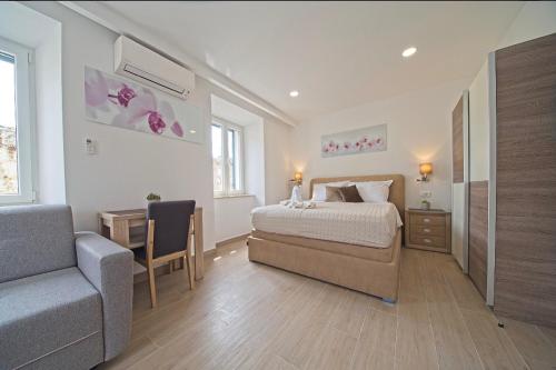 a bedroom with a bed and a chair and a couch at Villa Radić in Ston