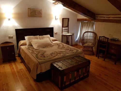 a bedroom with a bed and a table and a chair at El Rincón de los Poetas in Cuenca