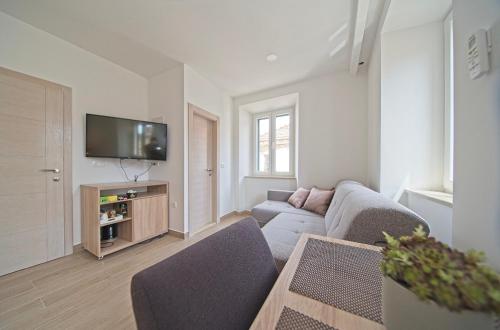 a living room with a couch and a tv at Villa Radić in Ston