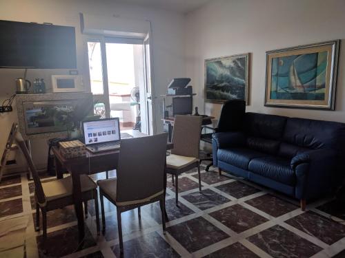 een woonkamer met een bank en een tafel met een laptop bij Il sogno della sirena in Alghero
