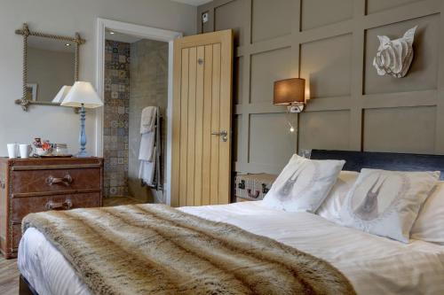 a bedroom with a large bed with a blanket on it at Beck Hall in Malham