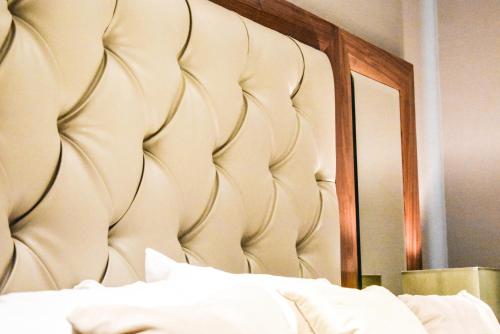 a bedroom with a large headboard and a mirror at Dalziel Park Hotel in Motherwell