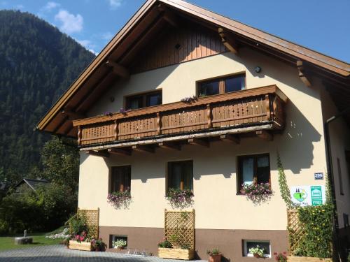 a building with a balcony and flowers on it at Haus Rye in Obertraun