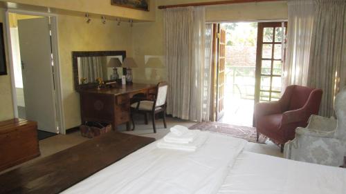 a bedroom with a bed and a desk and a mirror at 12 FLEETWOOD in Harare