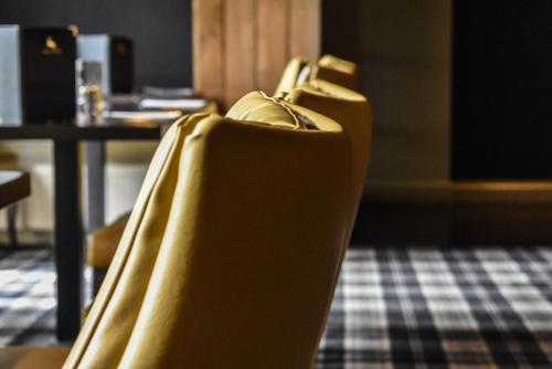 a couple of yellow chairs in a room at Dalziel Park Hotel in Motherwell