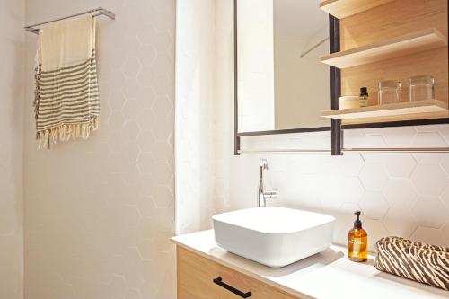 a bathroom with a white sink and a mirror at Sunprime Protaras Beach - Adults Only in Protaras