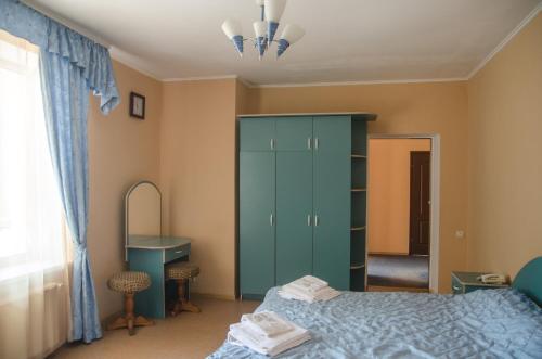 a bedroom with a green cabinet and a desk at Galant Hotel in Boryspilʼ