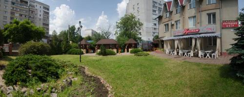 a park in the middle of a city with buildings at Galant Hotel in Boryspilʼ