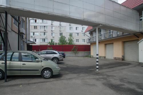 two cars parked in a parking lot next to a building at Galant Hotel in Boryspilʼ