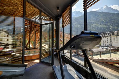 a gym with a view of the mountains through windows at Alpina Eclectic Hotel in Chamonix