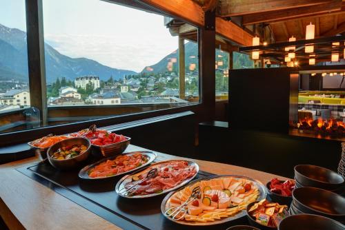 a table with several dishes of food on it at Alpina Eclectic Hotel in Chamonix-Mont-Blanc