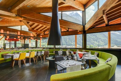 a restaurant with tables and chairs and large windows at Alpina Eclectic Hotel in Chamonix-Mont-Blanc
