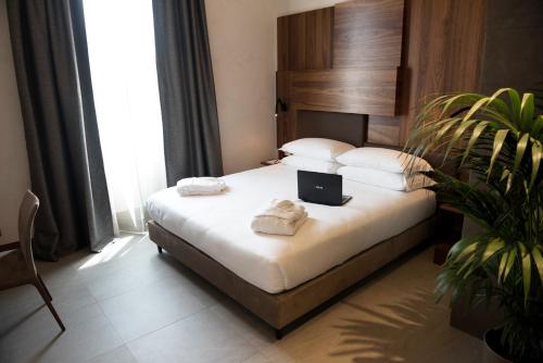 a bedroom with a bed with a laptop on it at Gasometer Urban Suites in Rome