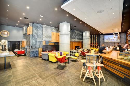 a restaurant with yellow and red chairs and tables at Alpina Eclectic Hotel in Chamonix-Mont-Blanc