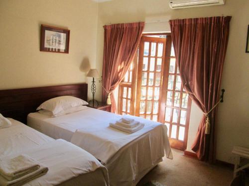 a bedroom with two beds and a large window at 12 FLEETWOOD in Harare