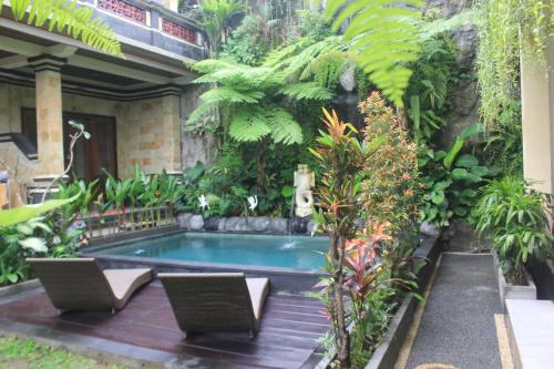 a swimming pool in the middle of a garden at Donald Home Stay in Ubud