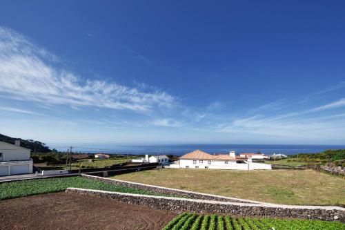 a view of a house with the ocean in the background at Melo's Place in Madalena
