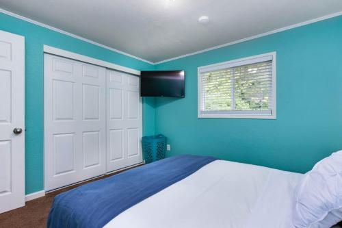 a bedroom with a white bed and blue walls at Bright Beach Town Bungalow in Gleneden Beach