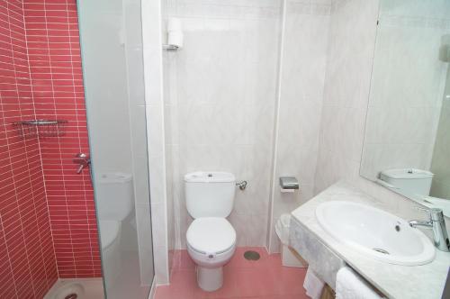 
a white toilet sitting next to a sink in a bathroom at Hotel Servigroup Orange in Benidorm
