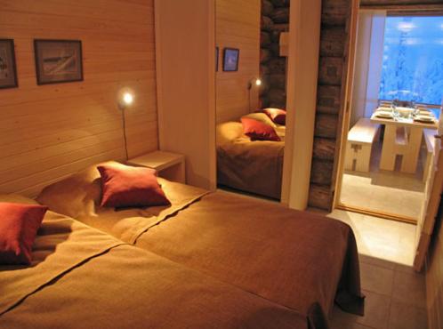 a bedroom with two beds and a large window at Kelokoto Chalets in Ruka