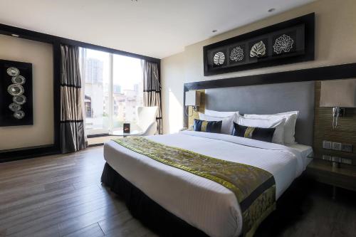 ムンバイにあるThe Empresa Hotelの大きなベッドと大きな窓のある寝室