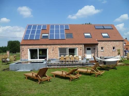 a house with a group of chairs and a house with solar panels at B&B Welcome Home in Laakdal