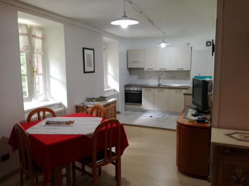 a kitchen and dining room with a red table and chairs at Appartamenti Acidule in Bagni di Rabbi