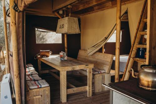 Valle de AbdalagísにあるCortijo Dos Santosのテーブルとテント内のベッド1台が備わる客室です。