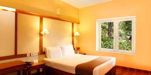 a hotel room with a bed and a window at Kodai Resort Hotel, Kodaikanal in Kodaikānāl