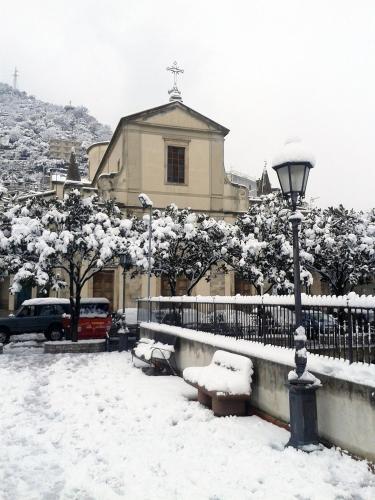a street light covered in snow in front of a church at Il Covo dei Re in Fiumedinisi