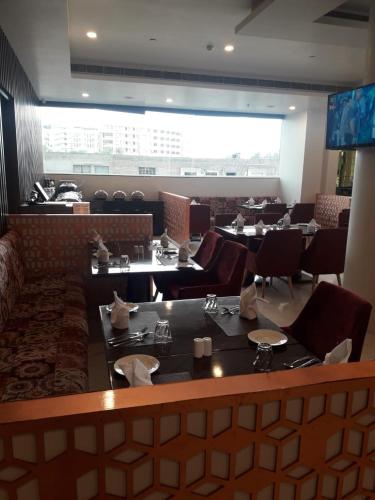 a dining room with tables and chairs in a restaurant at Days Hotel Jaipur Tonk Road By Wyndham in Jaipur