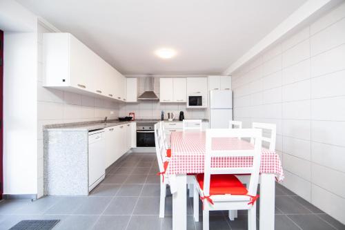 a kitchen with white cabinets and a table and chairs at Melo's Place in Madalena