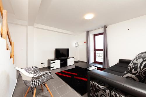a living room with a black couch and a chair at Melo's Place in Madalena