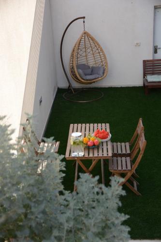 a patio with a swing and a table with fruit on it at Luna BaNeguev in Yeroẖam