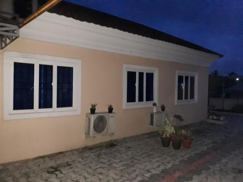 een huis met twee ramen en een open haard aan de voorkant bij Trendy T in Lagos
