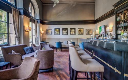 a bar with a row of chairs and a counter at Schlosshotel Karlsruhe in Karlsruhe