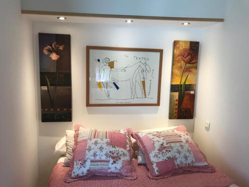 ein Schlafzimmer mit zwei Kissen und einem Bild an der Wand in der Unterkunft Le Vénitien in Arles