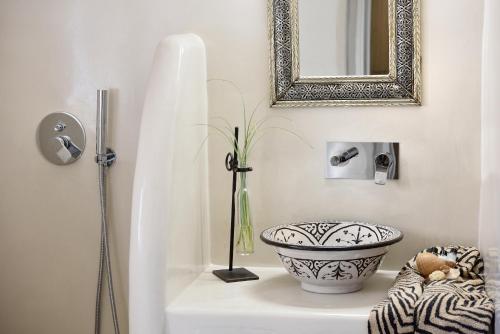 a bathroom with a sink and a mirror at ALIA MANSION by K&K in Megalokhori