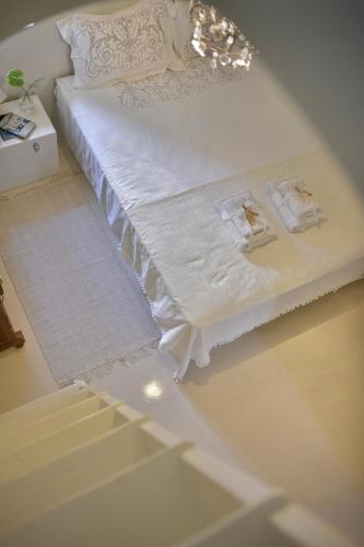 a white bed with white sheets on top of it at ALIA MANSION by K&K in Megalokhori