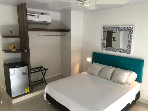 a bedroom with a bed with a blue headboard and a mirror at Sunshine Boutique Hotel in San Andrés