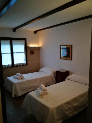 a room with two beds and a window at La pension del Parador in Galisteo