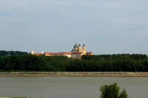 a building on top of a hill next to a river at Landhotel Wachau - Hotel Garni in Emmersdorf an der Donau