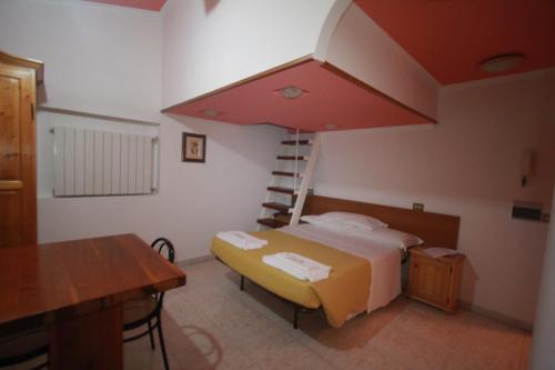 Un dormitorio con una cama, un escritorio y una mesa. en Villa Patrizia, en Mostacciano