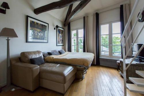 un salon avec un canapé et une table dans l'établissement Luxurious Duplex - Top of Montmartre, à Paris