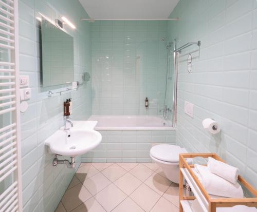 a bathroom with a sink and a toilet and a tub at 4 Elements Apartments by Adrez in Prague