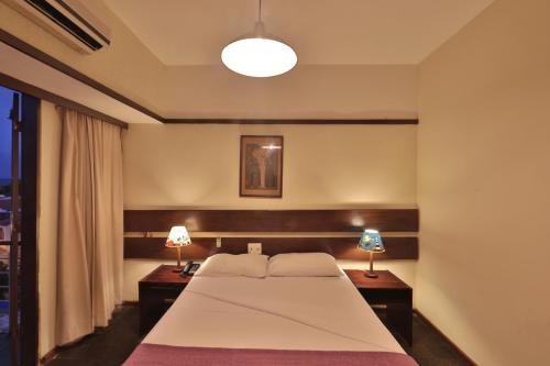a bedroom with a large bed and two lamps at Hotel Pousada São Francisco in Olinda