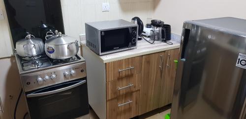 a kitchen with a microwave and a stove and a refrigerator at Asa Luxury 2Bedroom Apartment in Port Harcourt